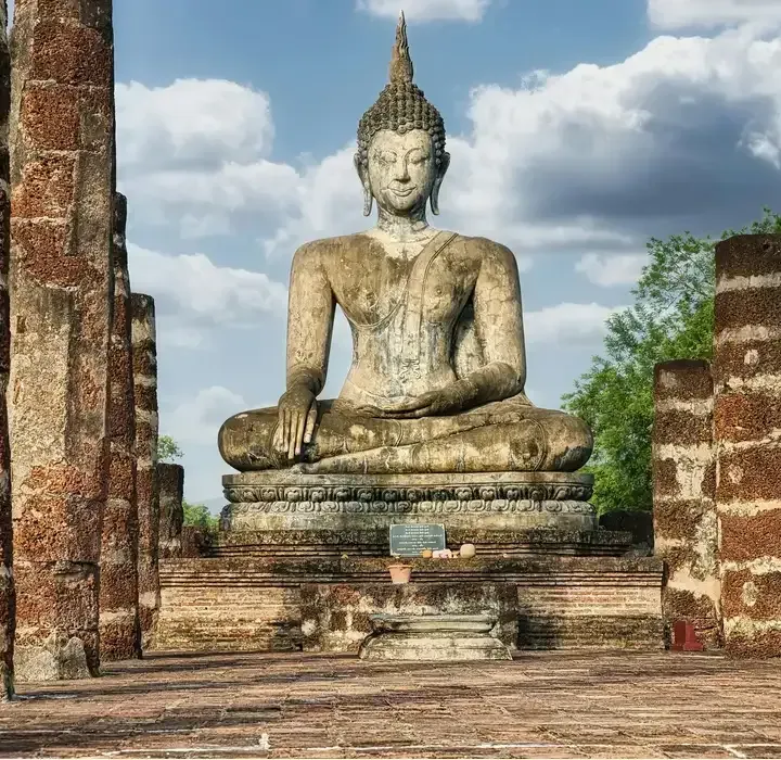 Ancient seated Buddha statue at Sukhothai Historical Park, a UNESCO World Heritage site in Thailand