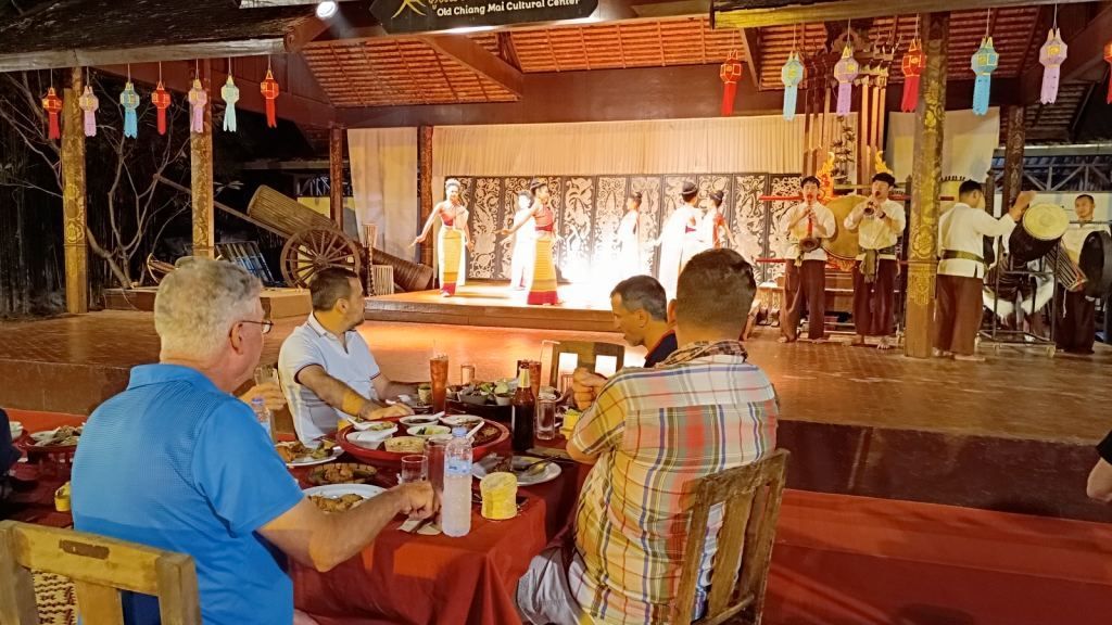 Motorcycle tour guests enjoying a traditional Thai dinner show at a cultural venue in Chiang Mai