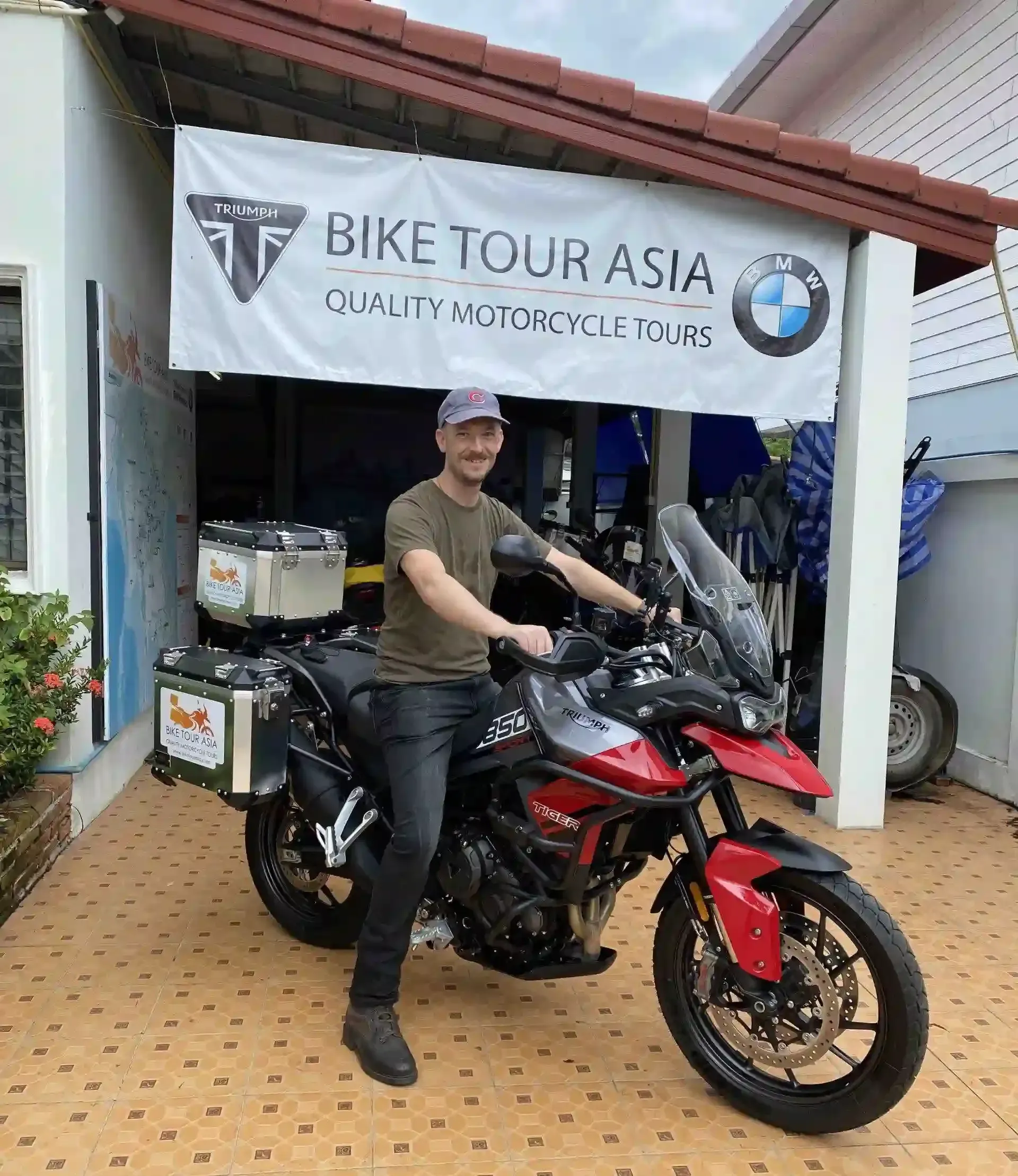 Rider sitting on a Triumph Tiger 850 motorcycle at Bike Tour Asia garage before a self-guided tour