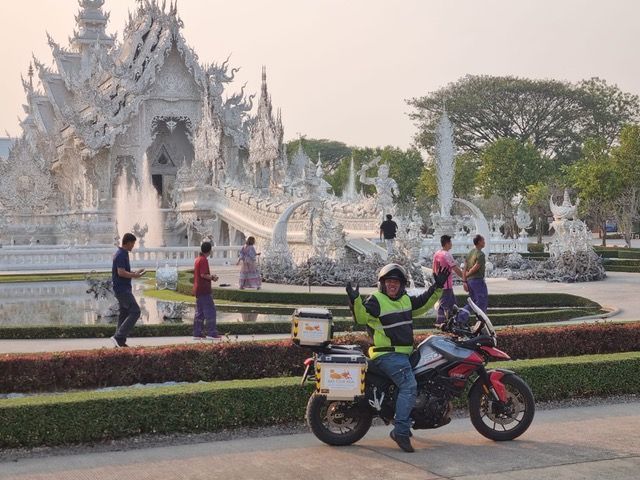 Motorcyclist visiting the iconic White Temple (Wat Rong Khun) in Chiang Rai, Thailand