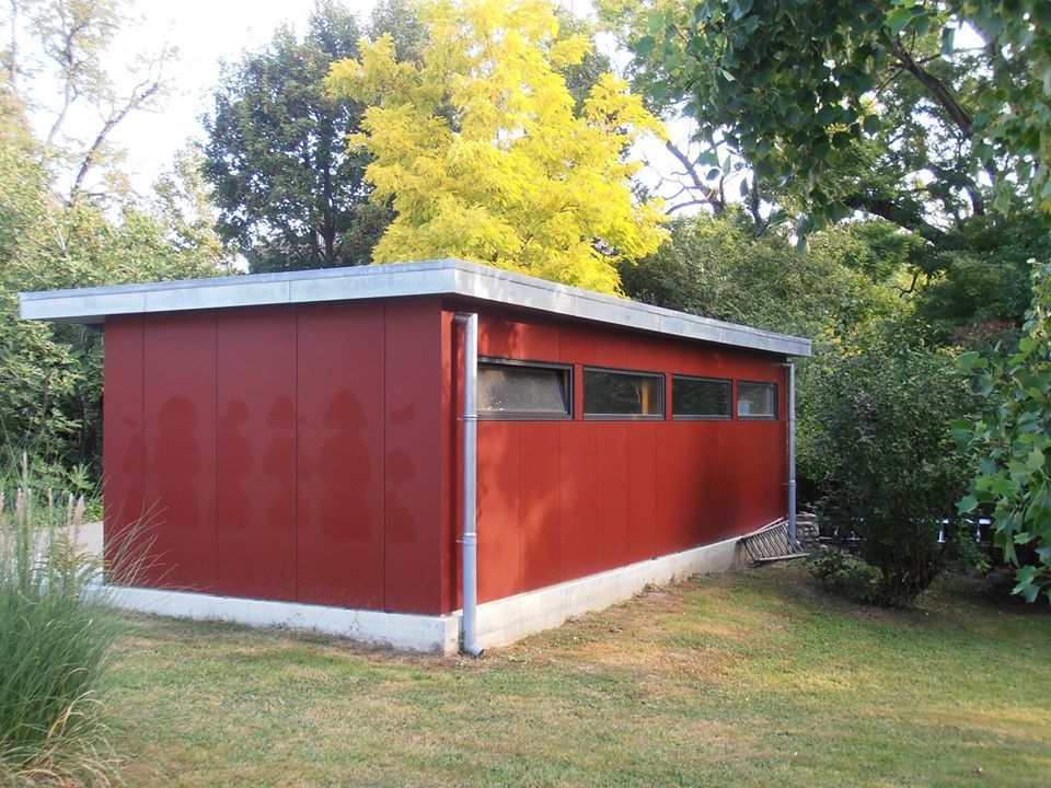 bardage rouge pour petit bâtiment dans un jardin