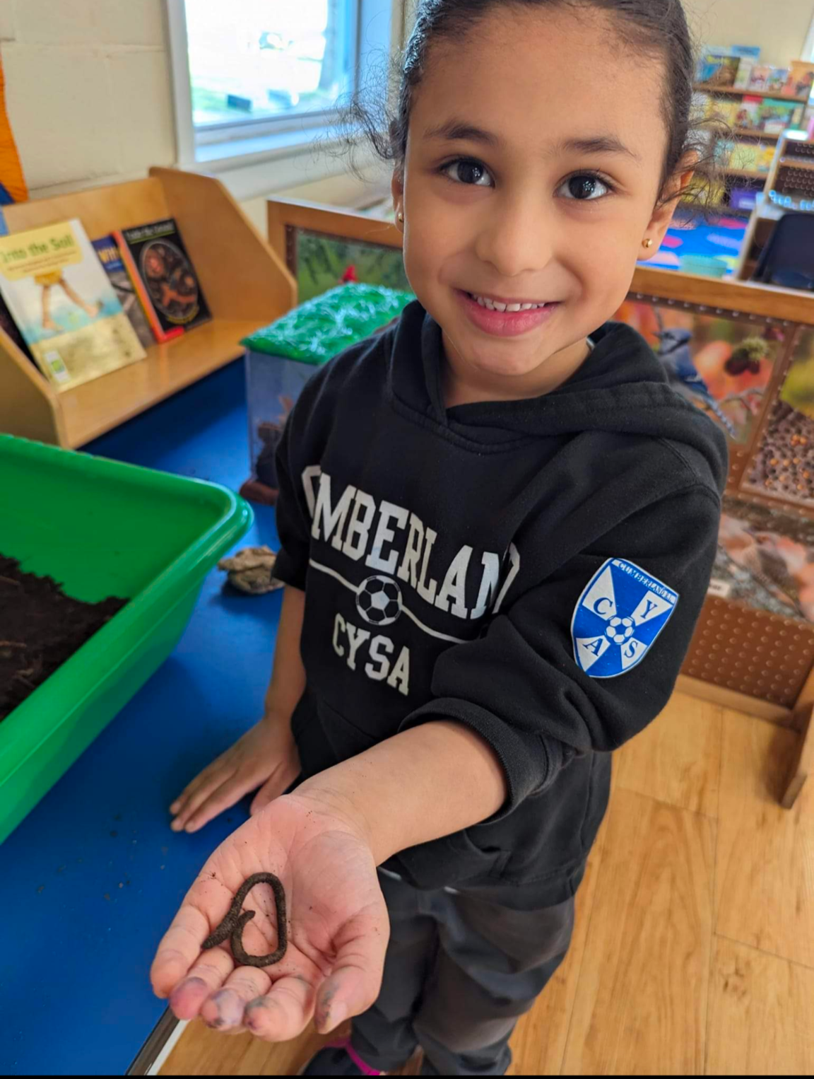 A young girl wearing a sweater that says ' amberlan ' on it