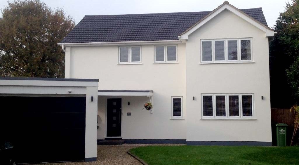 A white house with a black garage and a black door