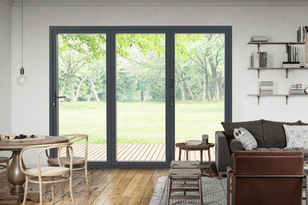 A living room with a couch , chairs , table and sliding glass doors.