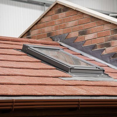 There is a skylight on a warm roof of a brick building.