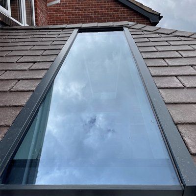 There is a skylight on a warm roof of a house.