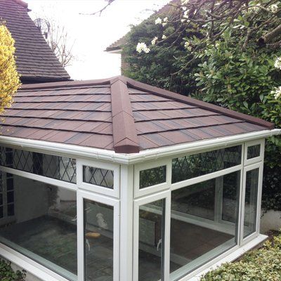 A conservatory with a warm roof and a lot of windows.