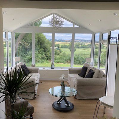 A living room with a couch and a table with a view of a field.