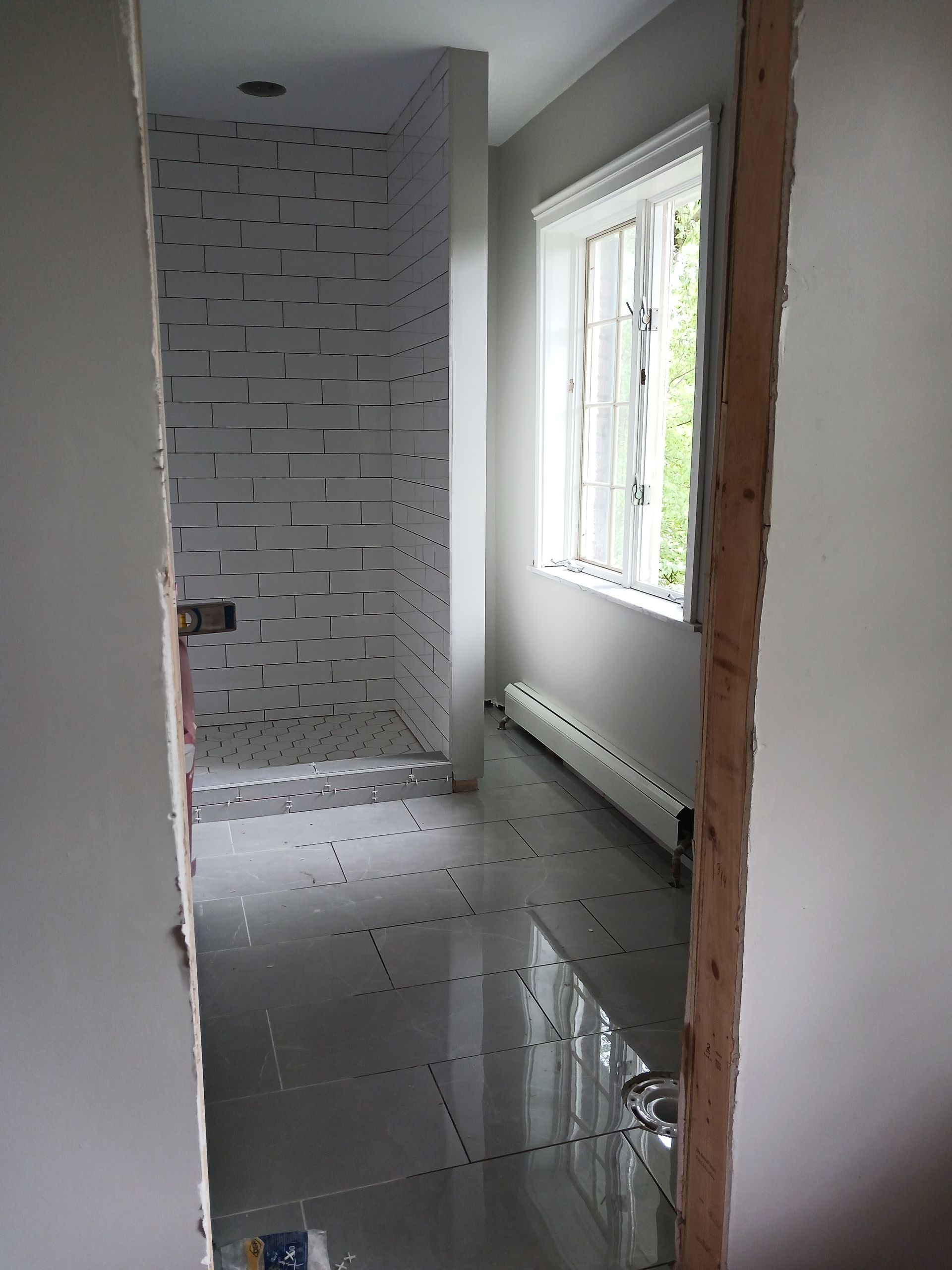 A room with a window and a tiled floor