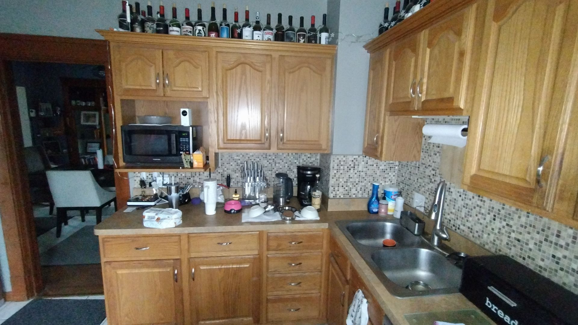 A kitchen with wooden cabinets and a stainless steel sink