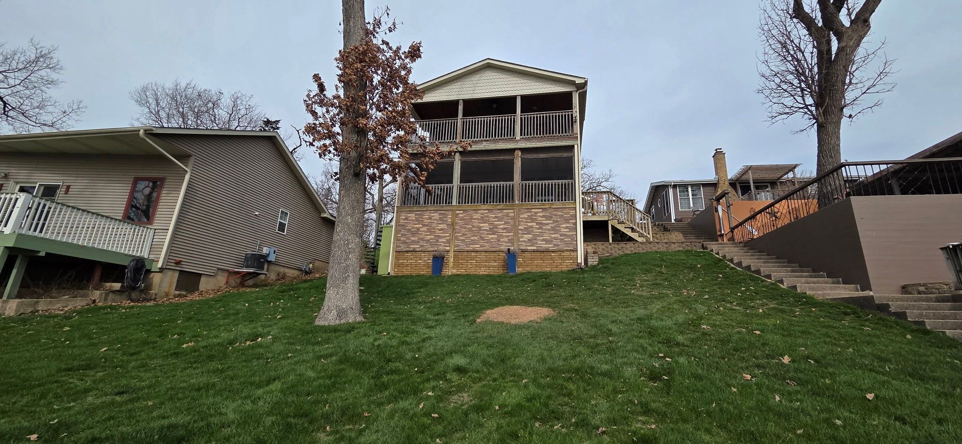 A large house is sitting on top of a lush green hill.