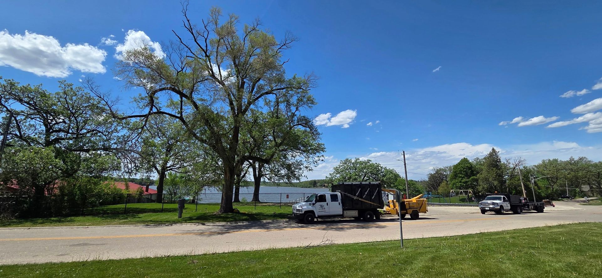 A white van and a yellow truck are parked in a parking lot.