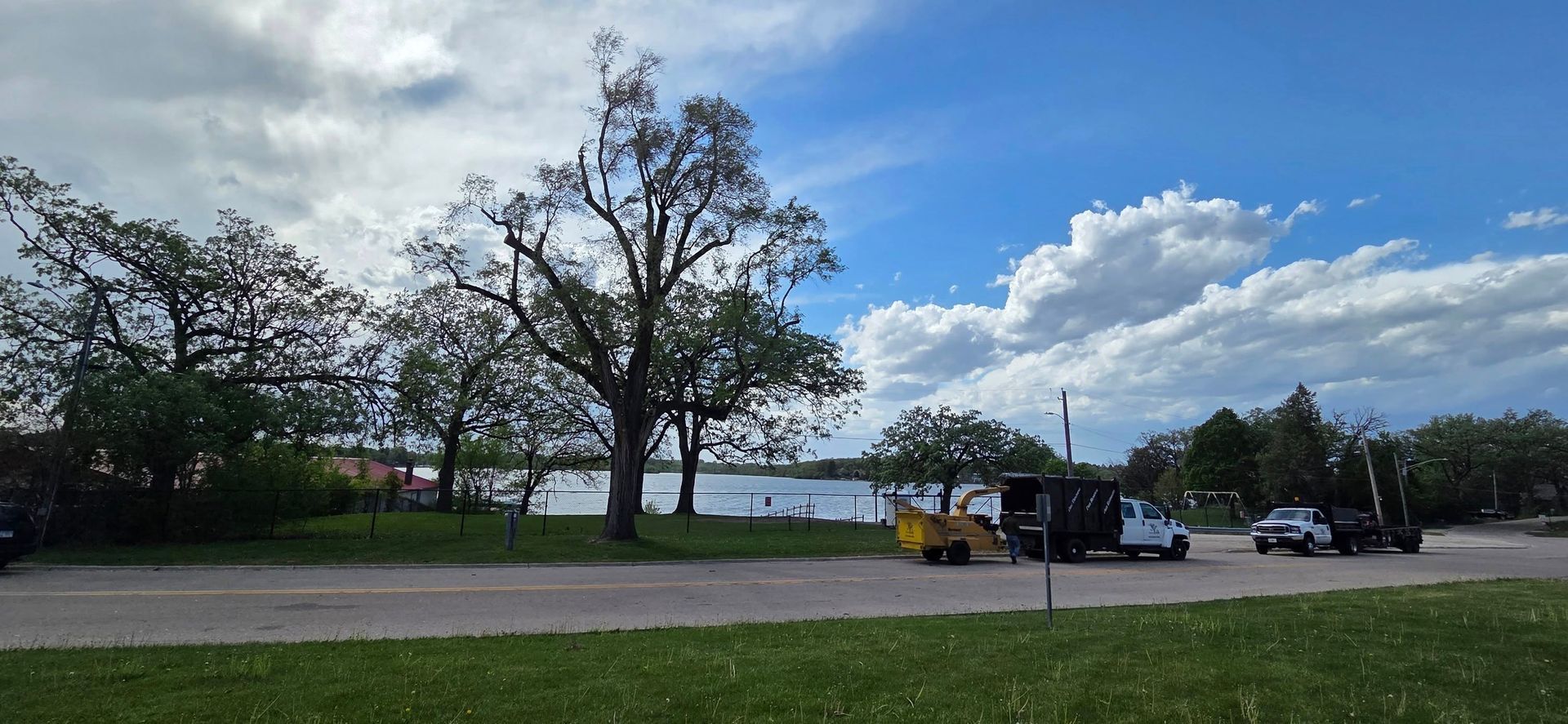 A group of cars are parked in a parking lot next to a lake.