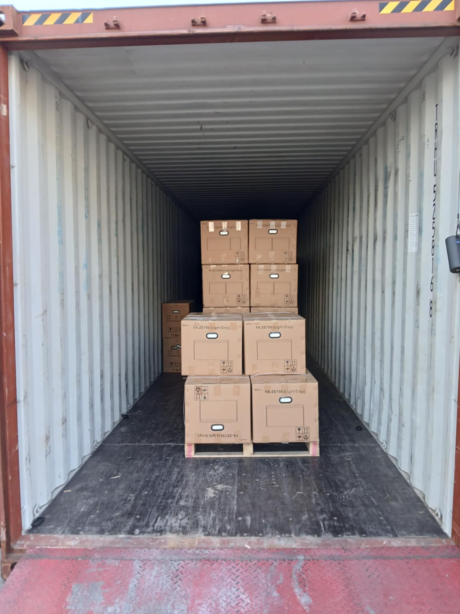 A shipping container filled with cardboard boxes and pallets