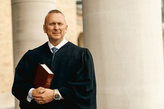 Judge O'Grady - a man - in a judge 's robe is holding a bible.