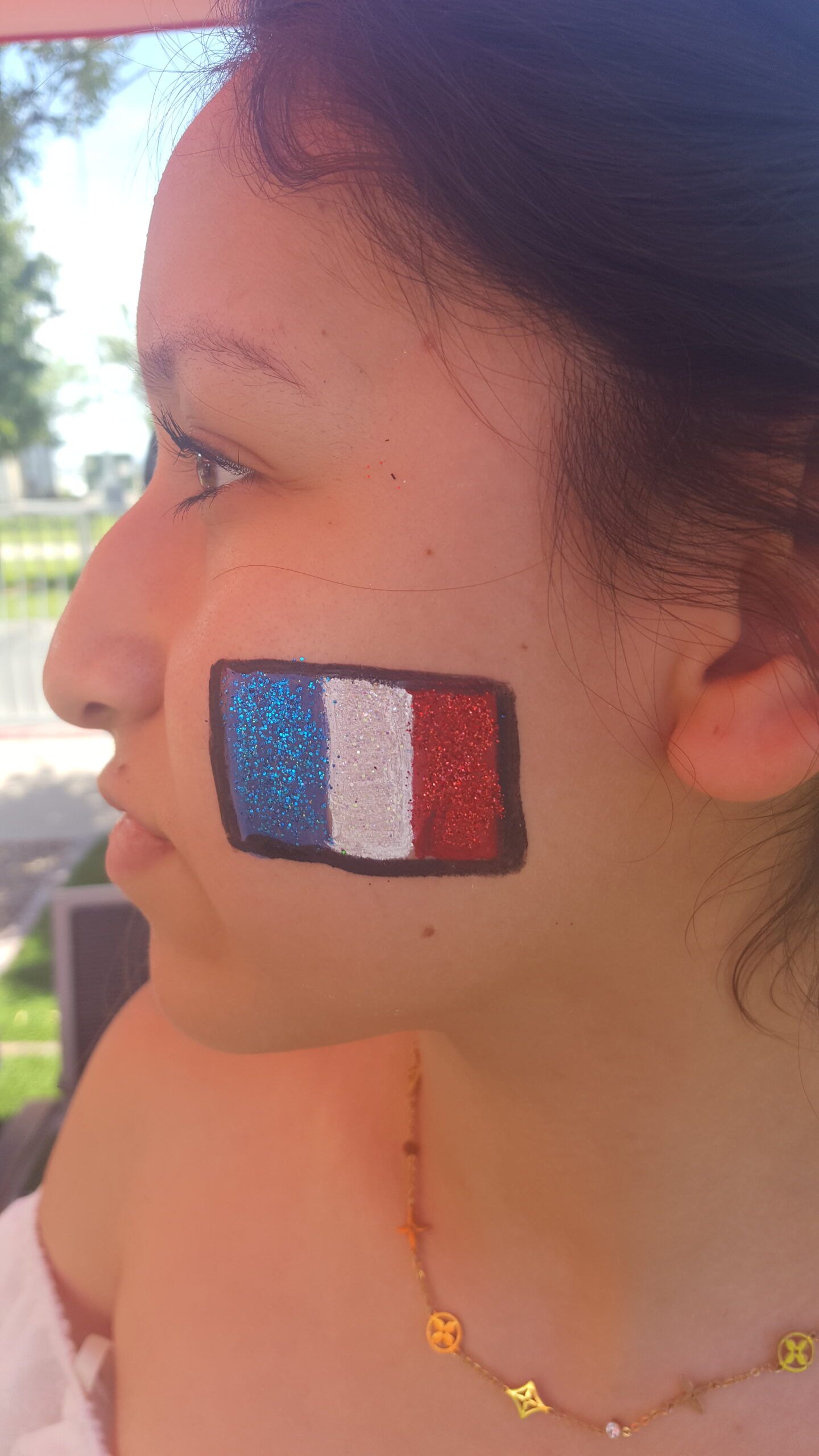 A woman with a french flag painted on her face.