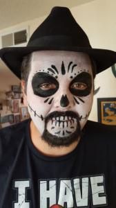 A man with face paint and a hat is wearing a shirt that says i have