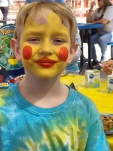 A young boy with pikachu painted on his face