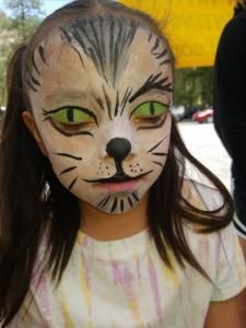 A little girl with her face painted like a cat