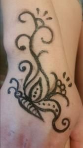 A person has a tattoo of a butterfly on their hand.