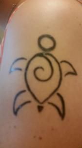 A person has a tattoo of a turtle on their back
