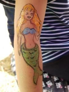 A person has a mermaid tattoo on their arm.