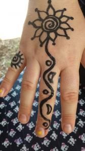 A close up of a person 's hand with a henna tattoo on it.