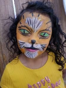 A little girl with her face painted like a tiger
