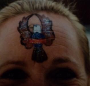 A woman has an eagle painted on her forehead