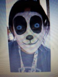 A person is wearing a panda mask on their face.