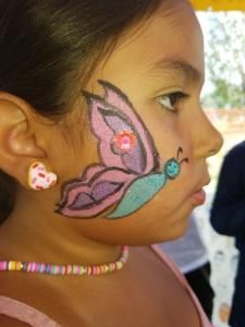 A little girl has a butterfly painted on her face
