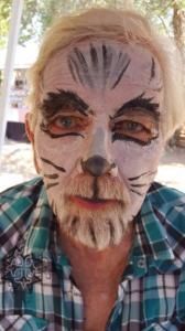 A man with his face painted like a cat.
