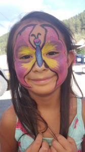 A little girl with a butterfly painted on her face.