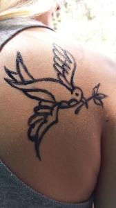 A woman has a bird tattoo on her back.