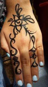 A woman 's hand with a henna tattoo on it.
