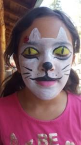 A little girl with her face painted like a cat.