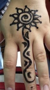 A close up of a person 's hand with a henna tattoo on it.
