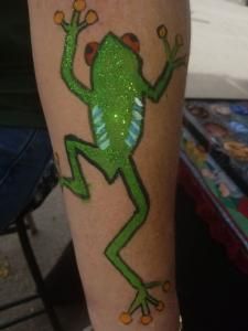 A person has a green frog painted on their arm