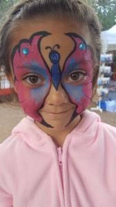 A little girl with a butterfly painted on her face.