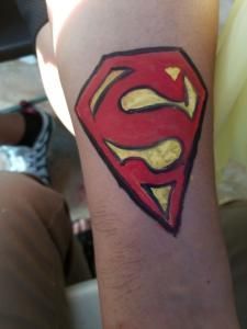 A person has a superman logo painted on their arm