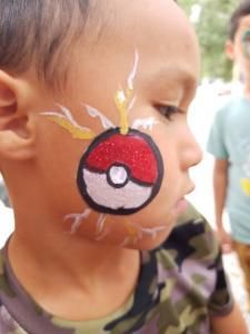 A young boy has a pokeball painted on his face
