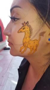 A woman with a giraffe painted on her face.