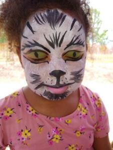 A little girl with her face painted like a cat