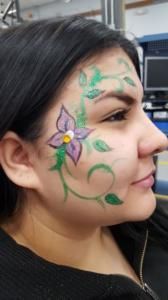 A woman has a flower painted on her face