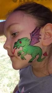 A little girl with a dragon painted on her face.