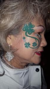 A woman with a clover painted on her face.