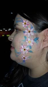 A woman with flowers painted on her face.