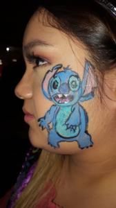 A woman has a drawing of stitch painted on her face.