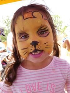 A little girl with her face painted like a cat
