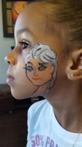 A little girl with a face painted on her face.